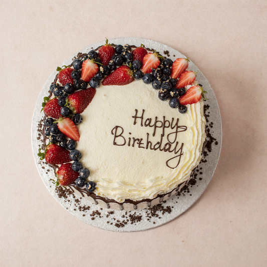 Birthday cake with berries and 'Happy Birthday' text on a beige background