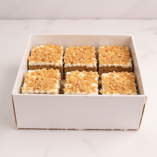 Box of six square dessert bars with a white background
