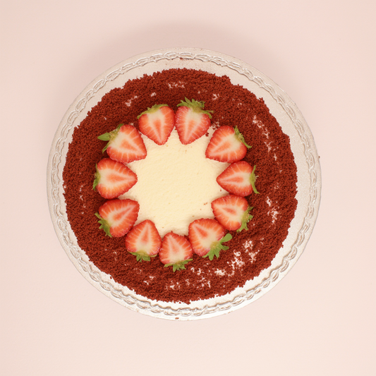 Dessert with red chocolate crumb topping and sliced strawberries on a light pink background